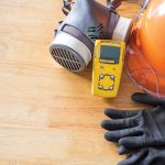 Standard personal protective equipment on wooden table. top view